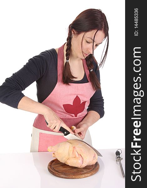 Beautiful housewife cutting chicken on white background