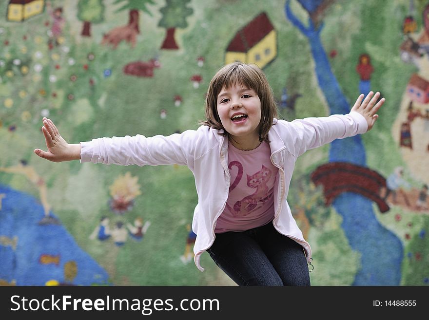 Happy young girl posing and jumping with abstract urban style painting bacground begind. Happy young girl posing and jumping with abstract urban style painting bacground begind