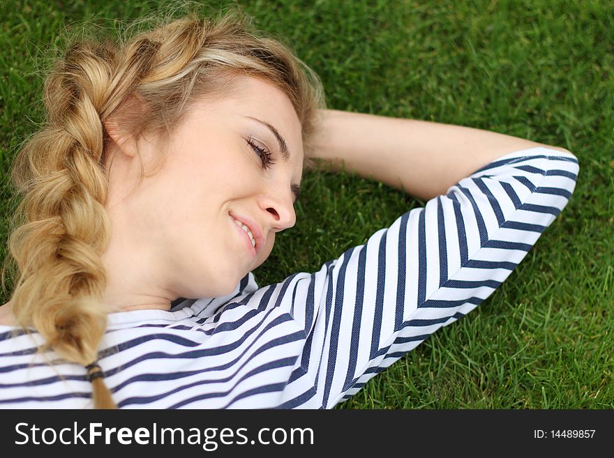 Portrait of the blond girl on the grass background. Portrait of the blond girl on the grass background