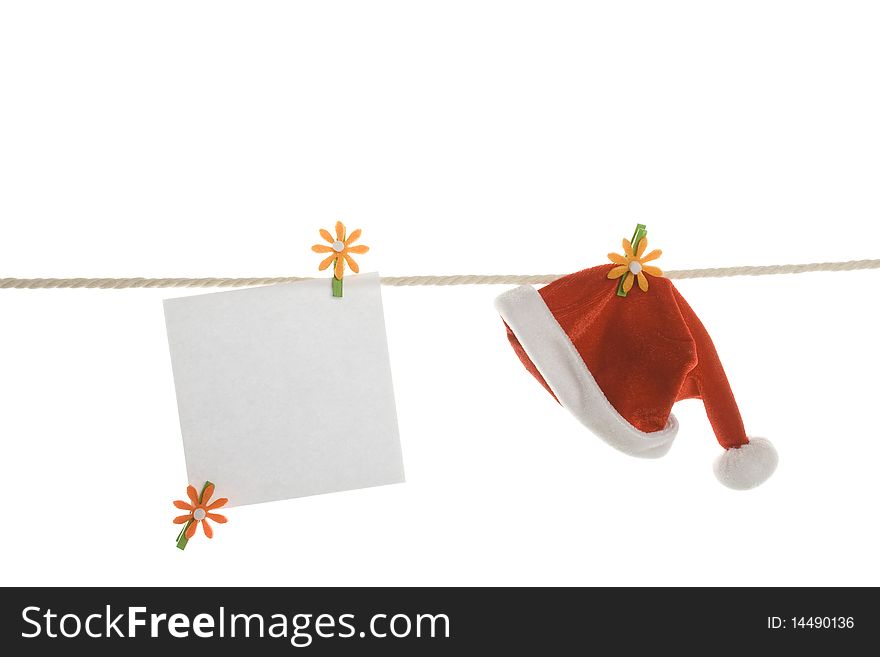 White blank and a red Santa's hat hanging on a rope. Isolated on white background. White blank and a red Santa's hat hanging on a rope. Isolated on white background