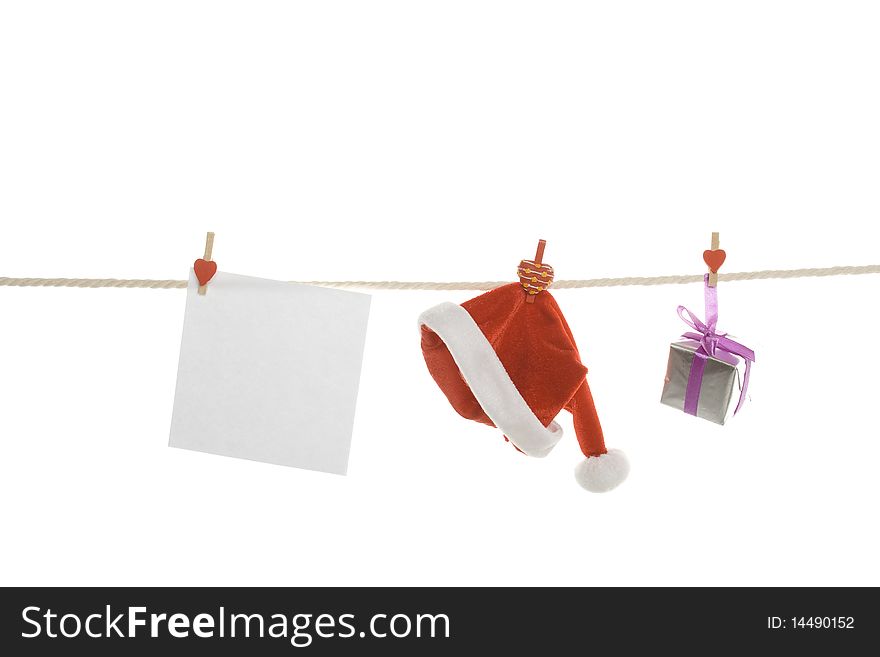 White blank, gift box and a red Santa's hat hanging on a rope. Isolated on white background. White blank, gift box and a red Santa's hat hanging on a rope. Isolated on white background