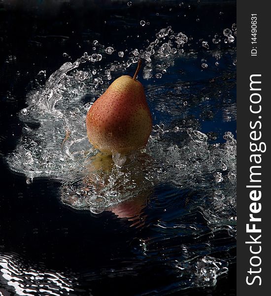 Pear with reflection in water splash studio shot. Pear with reflection in water splash studio shot