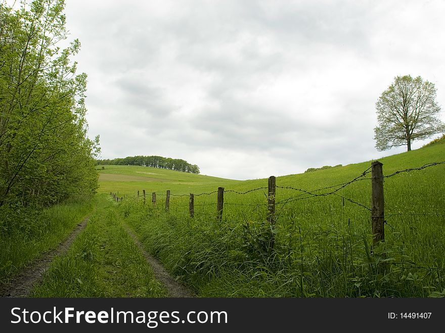 Country lane in front of green hills