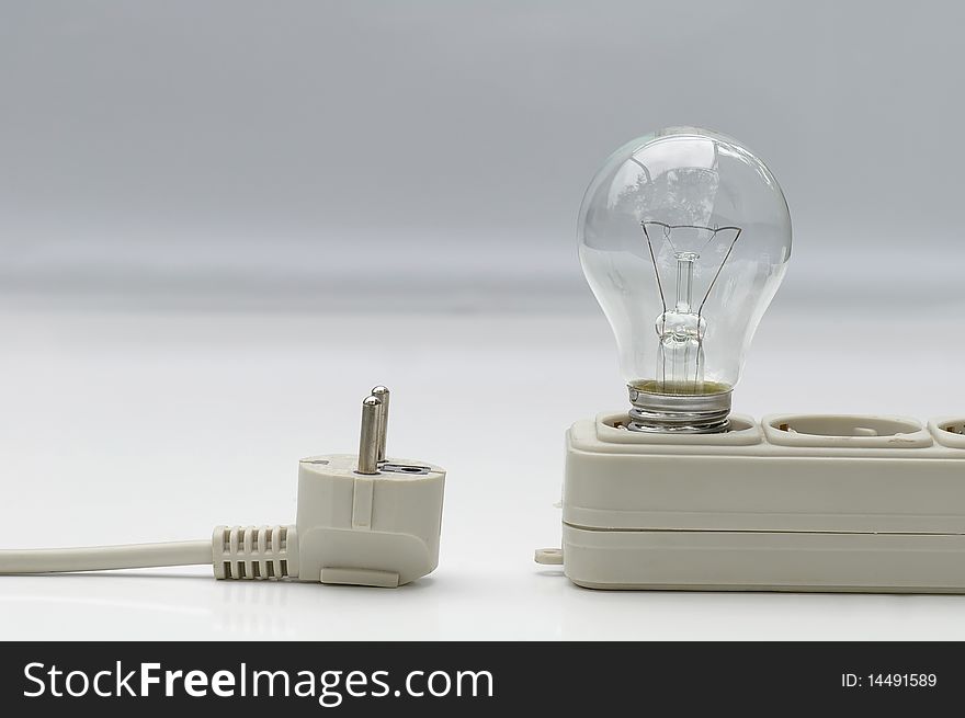 Electric lamp with extension plug-wire on light background