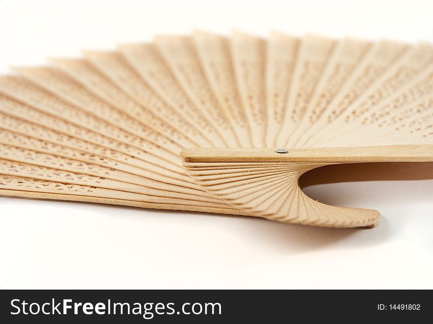 Light brown wooden Chinese fan, fanned out, on a white background