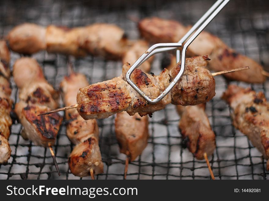 Roasted meat on wood sticks prepared for eating. Barbecue. Shallow depth of field. Roasted meat on wood sticks prepared for eating. Barbecue. Shallow depth of field.