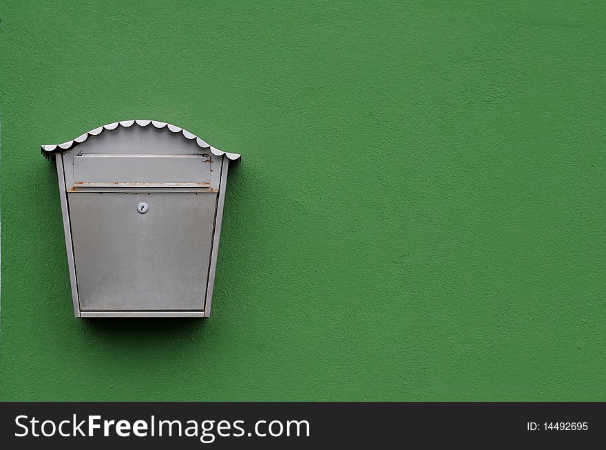Metal mailbox on green facade wall. Metal mailbox on green facade wall