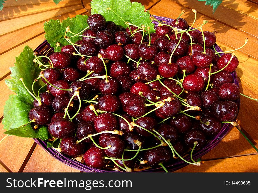 Basket of fresh red cherries with green leaves. Basket of fresh red cherries with green leaves