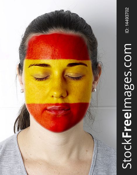 Spanish fan with painted flag on her face. Spanish fan with painted flag on her face.