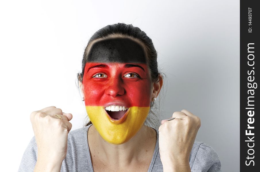 German fan screaming GOAL with hands up and painted flag on her face.