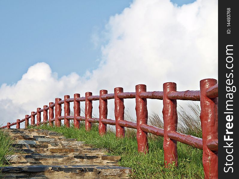 Red fences leading the path under beautiful blue s