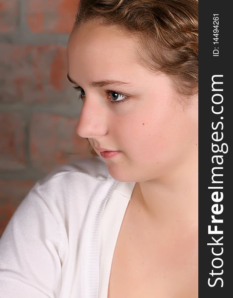 Beautiful teen with curly hair against a brickwall background