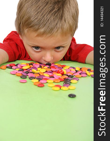 Young boy being with a table full of colorful sweets