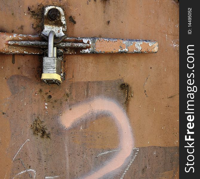 Old wooden door with paint marks and rusty padlock on lock. Old wooden door with paint marks and rusty padlock on lock.