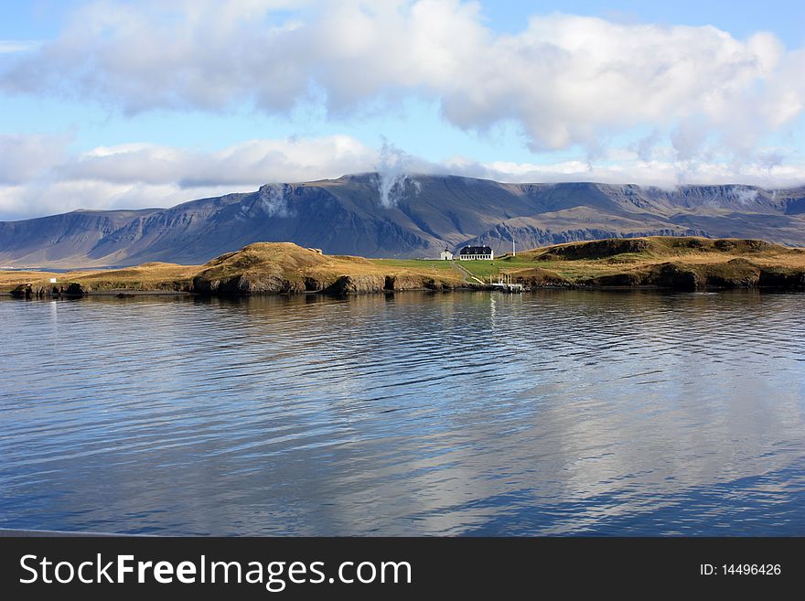 The view over the mountains of iceland, with farmer's house and the sea. The view over the mountains of iceland, with farmer's house and the sea