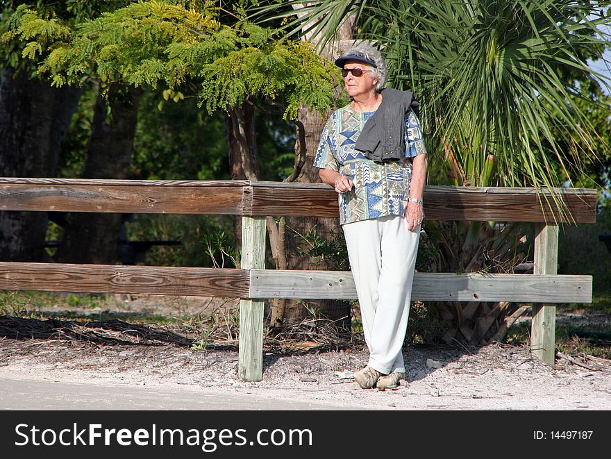 Elderly Woman Leaning on Fence Sanibel Florida
