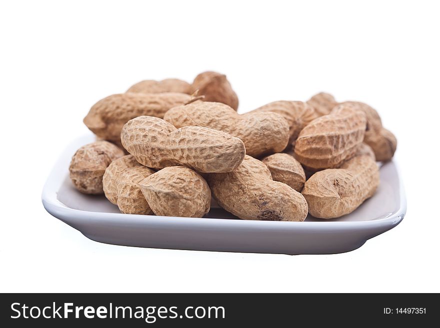 Roasted peanuts on plate isolated on white background