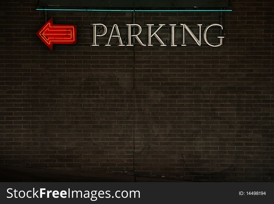 Parking sign and directional arrow, neon on a brick wall. Room for text and design. Parking sign and directional arrow, neon on a brick wall. Room for text and design.