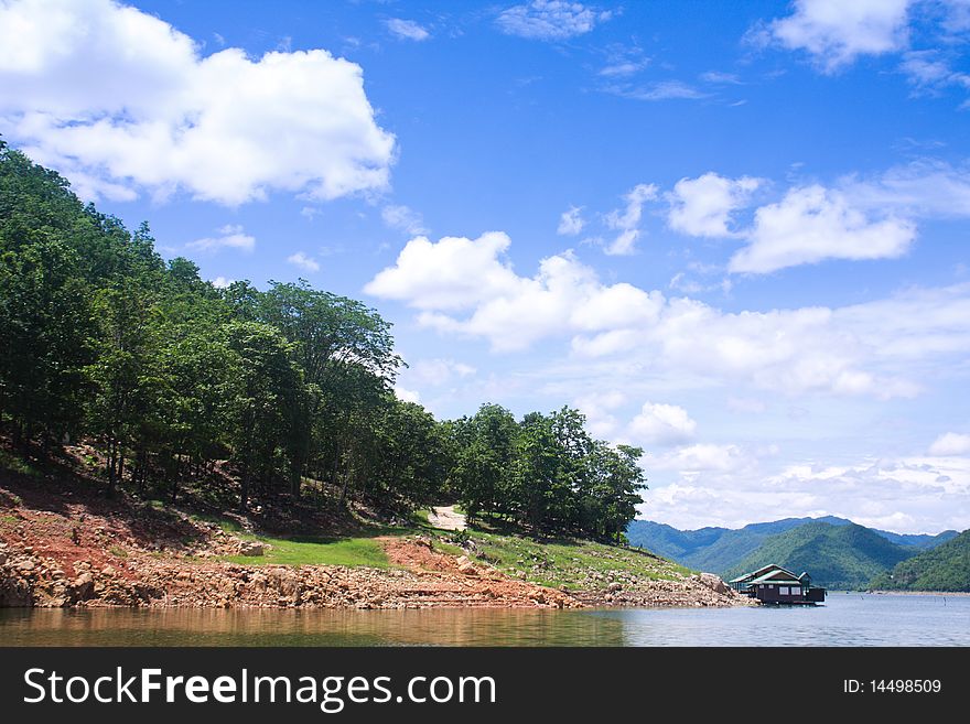 Houseboat and the mountain on the blue sky background. Houseboat and the mountain on the blue sky background