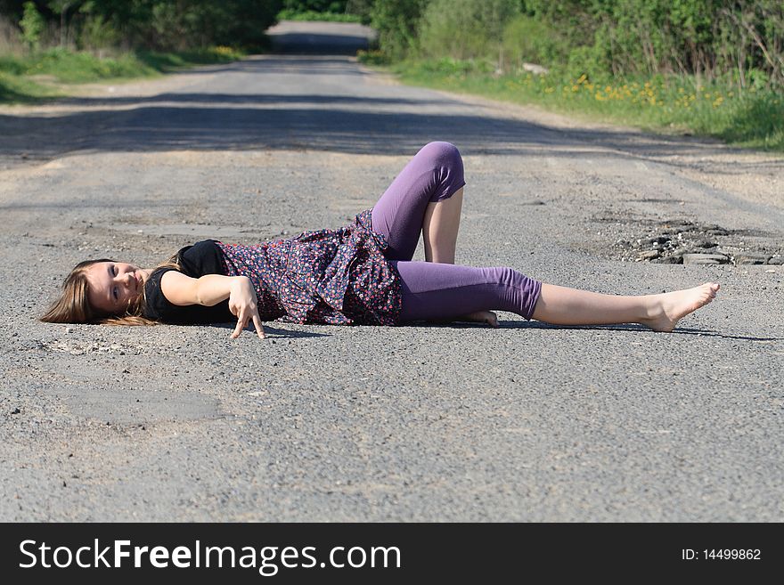 Beauty smiling teenage girl lying on old rural road. Beauty smiling teenage girl lying on old rural road