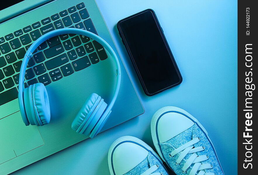 Modern laptop, wireless headphones, smartphone, sneakers