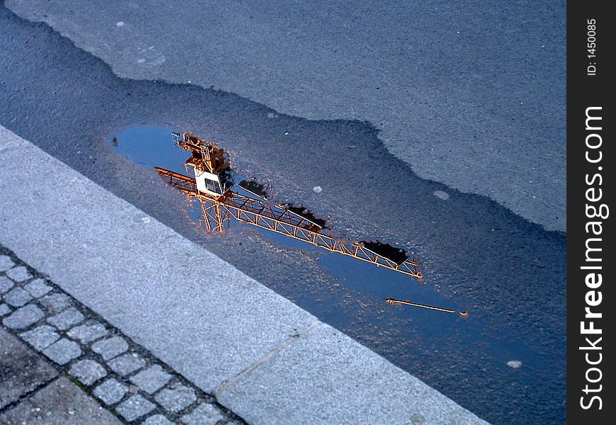 An image of a crane reflected in a puddle, taken in Berlin, Germany in 2005. An image of a crane reflected in a puddle, taken in Berlin, Germany in 2005