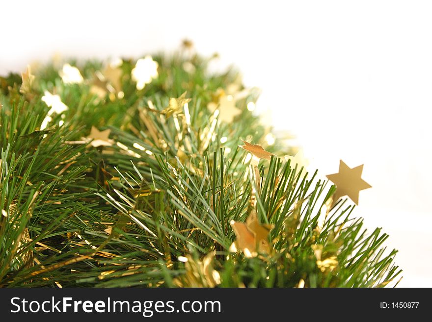 Close-up of green christmas garland with gold stars isolated on white