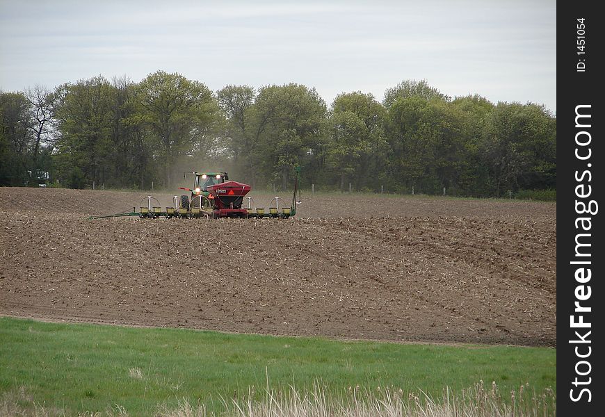 A farmer tilling his fields with his tractor. A farmer tilling his fields with his tractor.