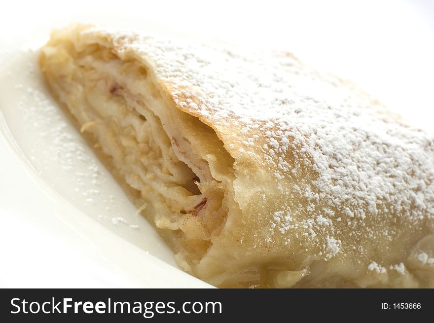 Sweet apple pie on white plate close up