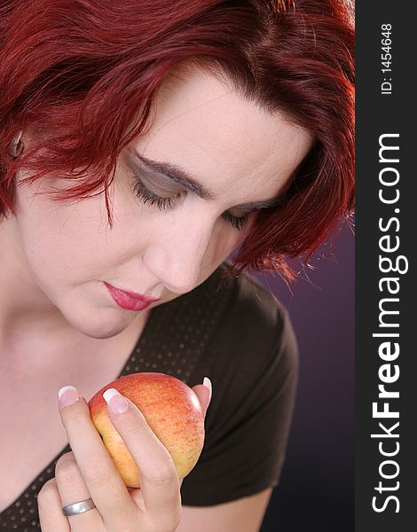 Beautiful girl looking at a fresh apple. Beautiful girl looking at a fresh apple