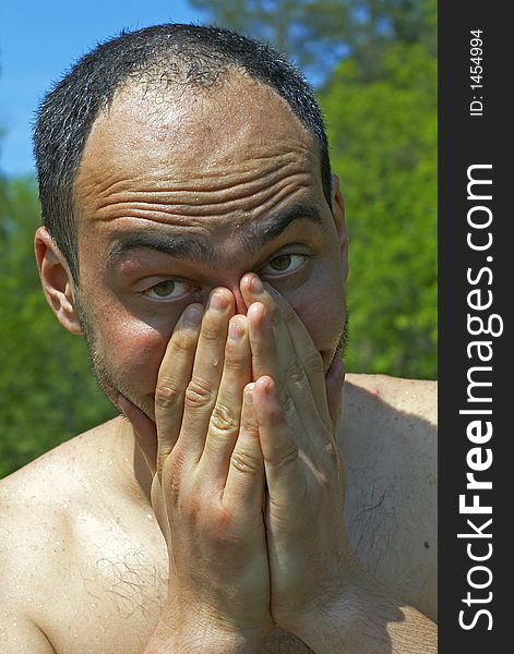 Young man looking through his fingers