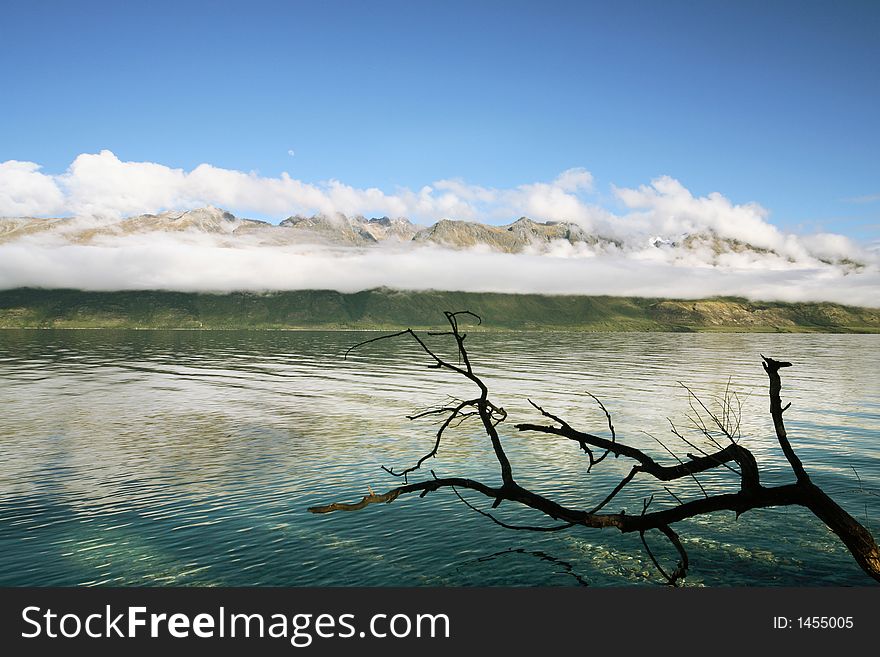 Clear Lake and beautiful mountains with a frame of branches at New Zealand. Clear Lake and beautiful mountains with a frame of branches at New Zealand