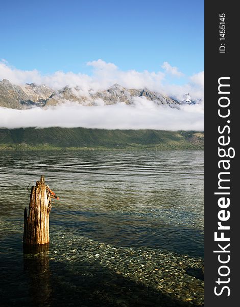 Clear lake and abandon pier in front of New Zealand Mountains