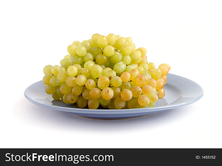 Green ripe grape on the blue plate