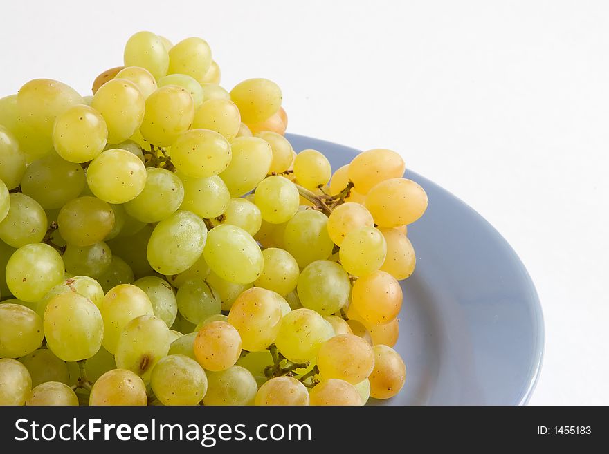 Green ripe grape on the blue plate