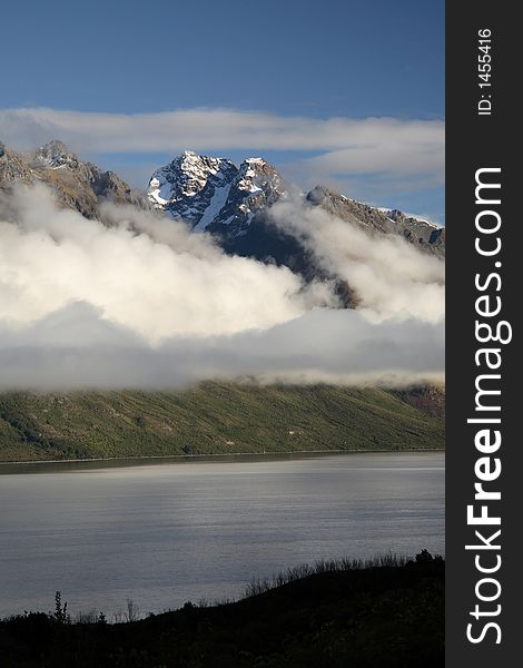 Cloudy mountain with snow on top and lake at New Zealand. Cloudy mountain with snow on top and lake at New Zealand