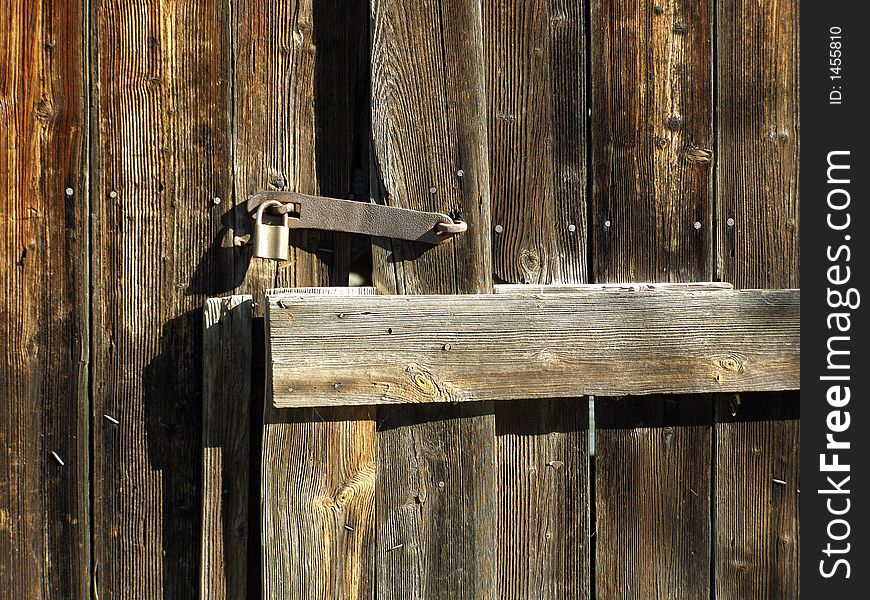 Old wooden door with metallic padlock. Old wooden door with metallic padlock
