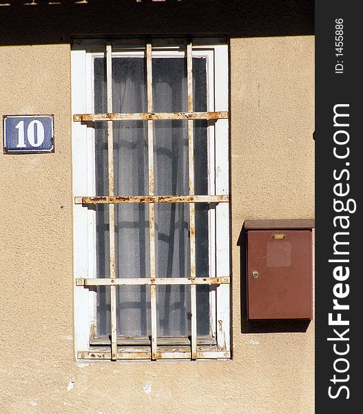 Old window with rusty fretwork and home number 10. Old window with rusty fretwork and home number 10