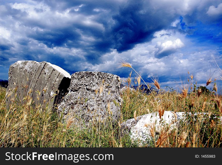 Remains of old roman abutment and epitaph with before storm clouds. Remains of old roman abutment and epitaph with before storm clouds.