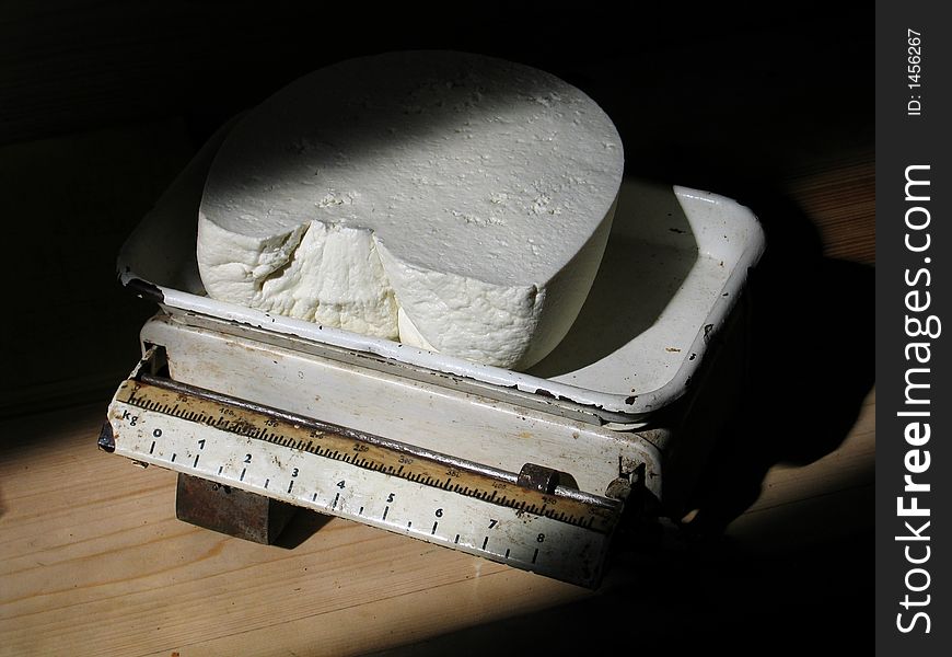 Big piece of cottage cheese cut off for a buyer and weighed on old scales. Big piece of cottage cheese cut off for a buyer and weighed on old scales.