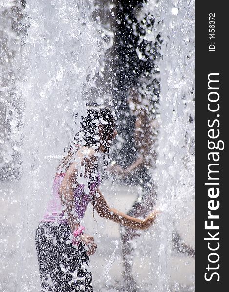 Young girl playing in fountain water. Young girl playing in fountain water