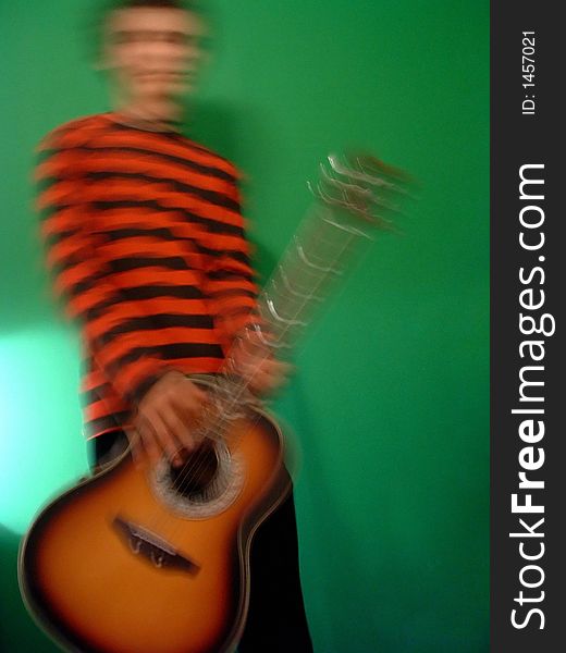 An image of a guitar player in a red and black striped jumper. An image of a guitar player in a red and black striped jumper