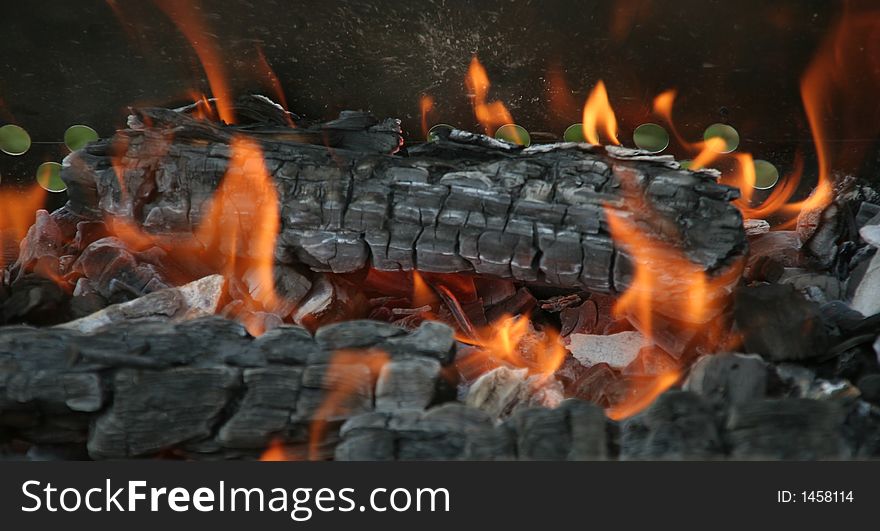 Hardly decaying - flickering fire on the burnt through coals. Hardly decaying - flickering fire on the burnt through coals