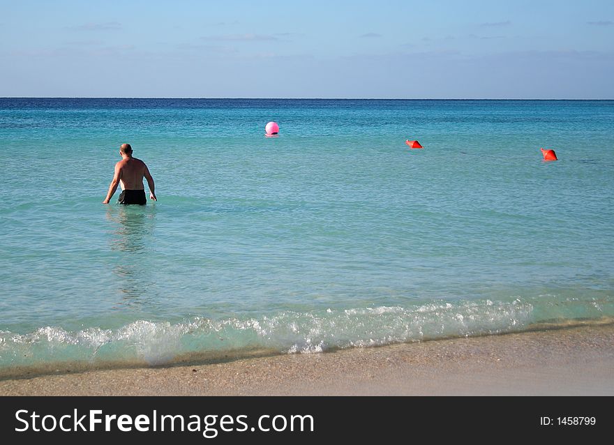 Man on the tropical beach going into the water. Man on the tropical beach going into the water