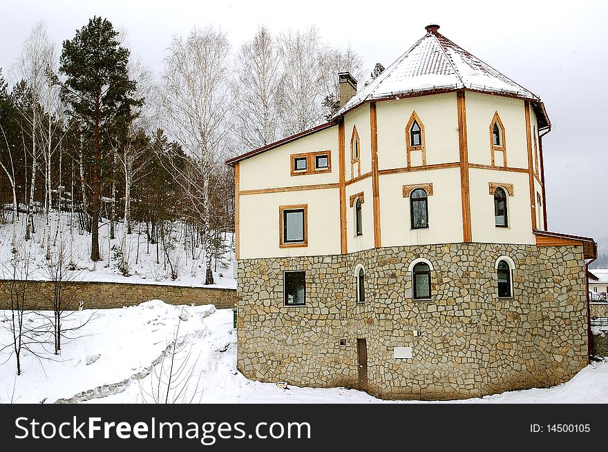 The high stone house in mountains, in the winter in wood in three floors