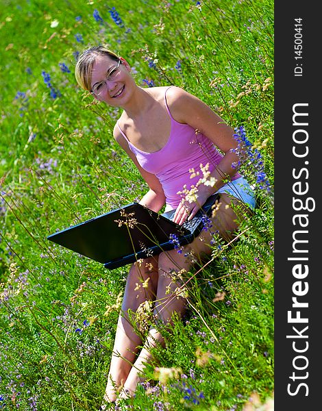 Beautiful young girls in nature using a computer. Beautiful young girls in nature using a computer.