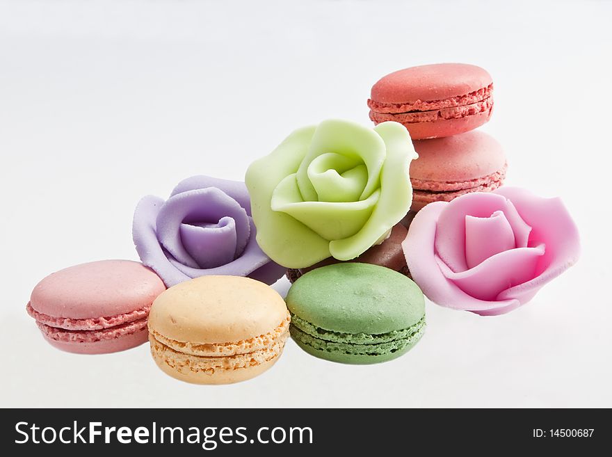 French macaroons with roses made of icing isolated in the studio. French macaroons with roses made of icing isolated in the studio