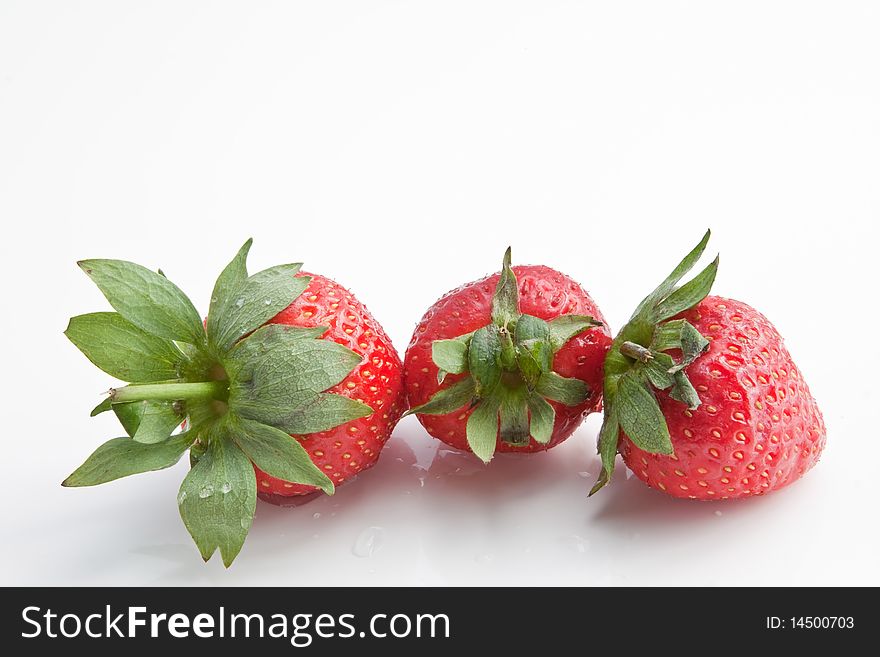 Three washed strawberries isolated against a white background