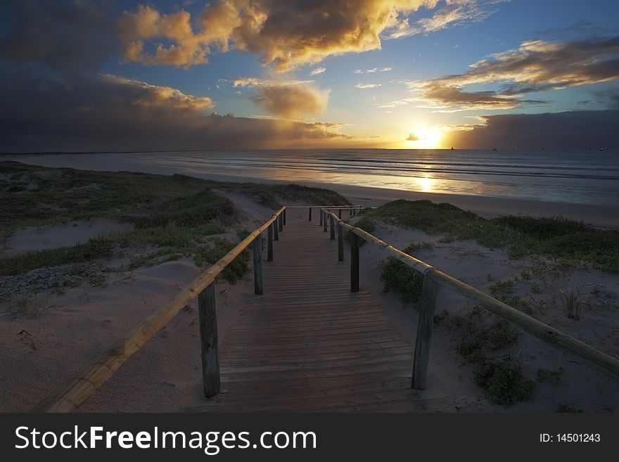 Image of a wooden walkway going on a beach. Image of a wooden walkway going on a beach