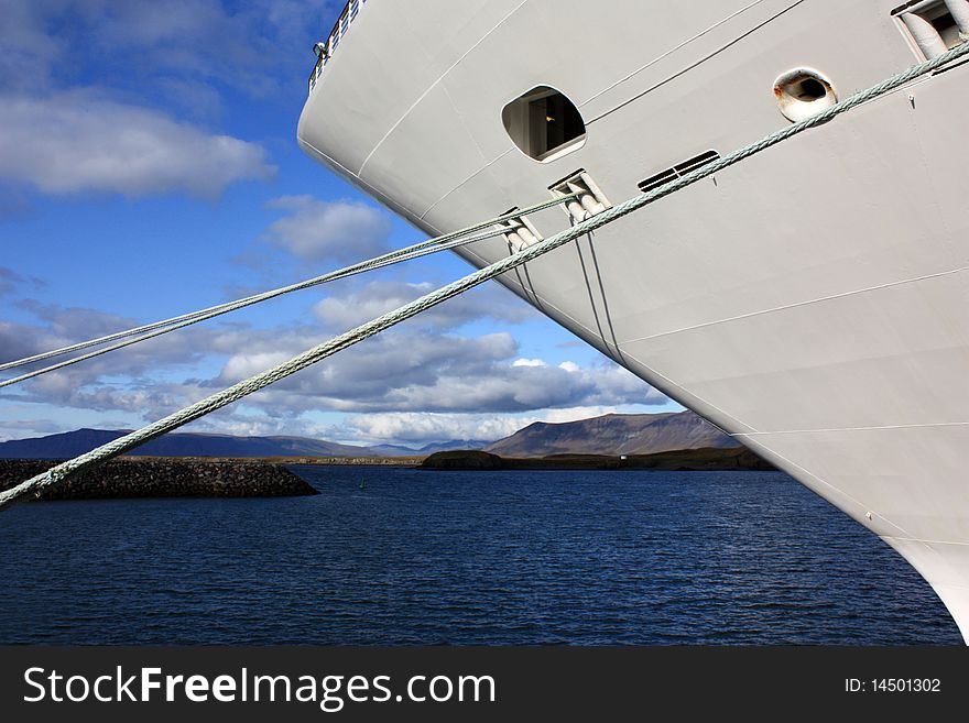 The image of the cruise ship's bow against icelandic mountainous landscape. The image of the cruise ship's bow against icelandic mountainous landscape